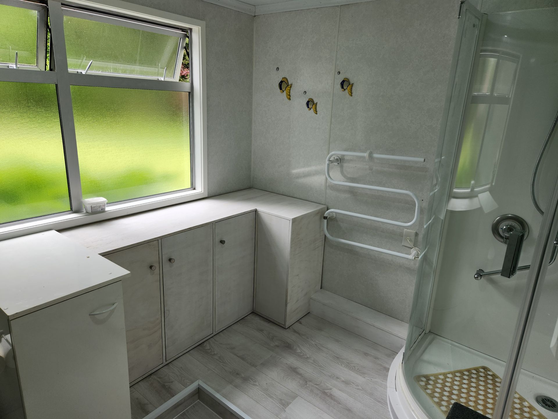 A bathroom with a shower and a window.