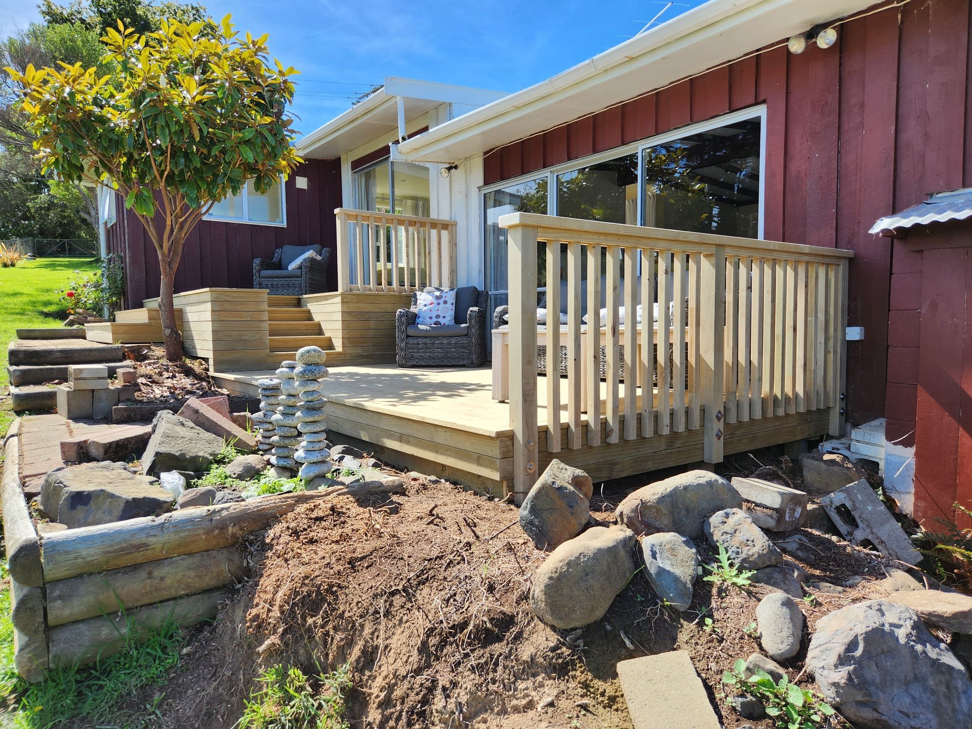 A red house with a wooden deck in front of it.