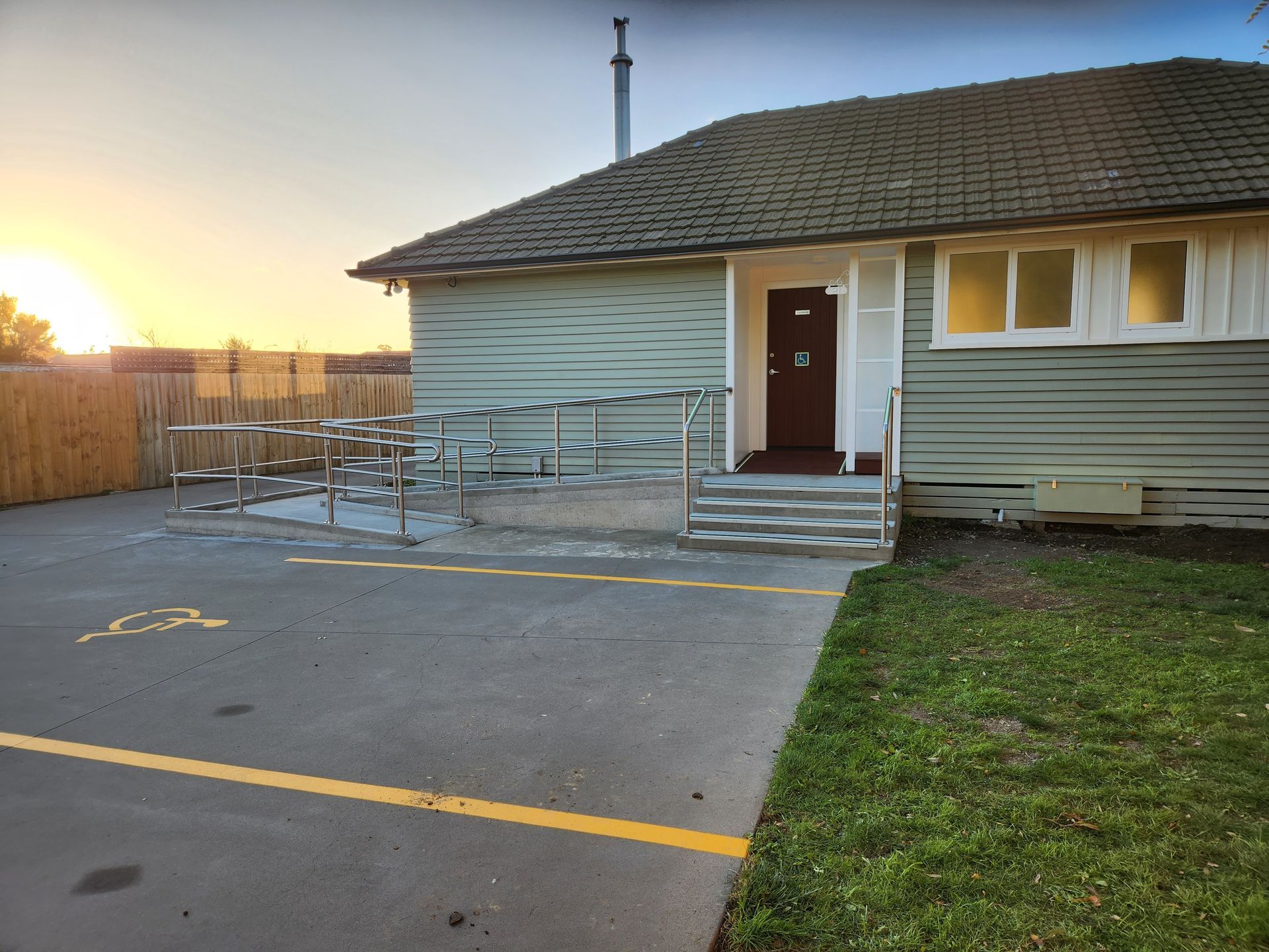 A small house with a handicapped ramp in front of it
