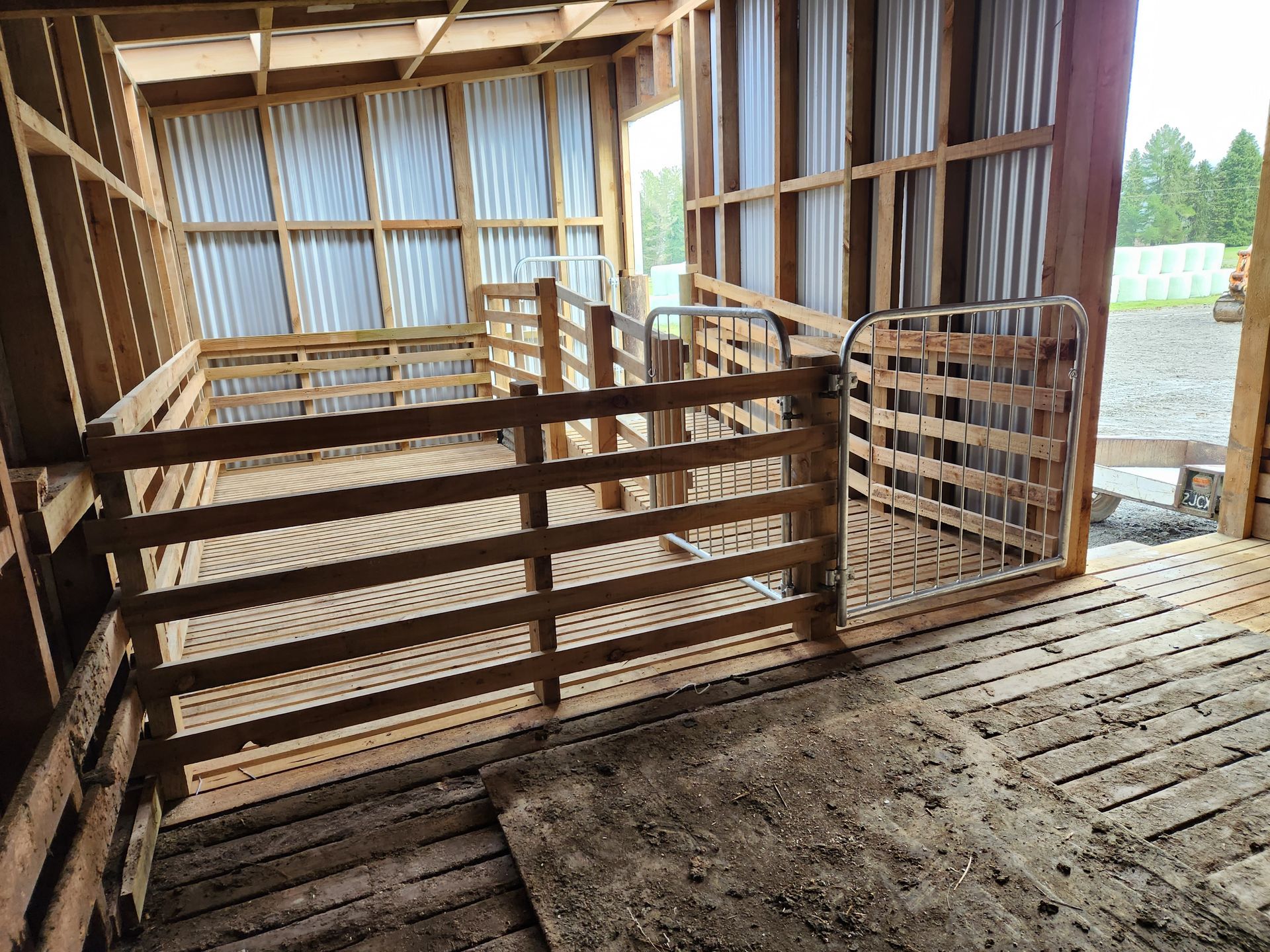 A wooden barn with a metal roof and a wooden fence.