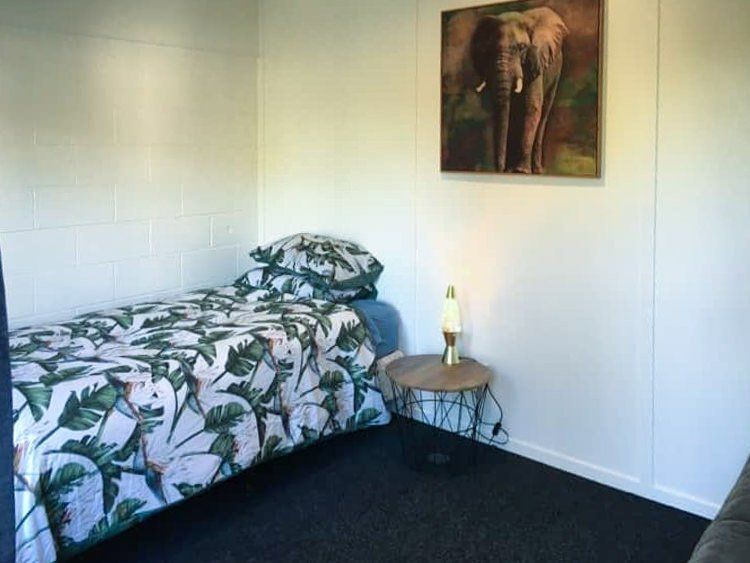 There is a picture of an elephant on the wall above the bed.