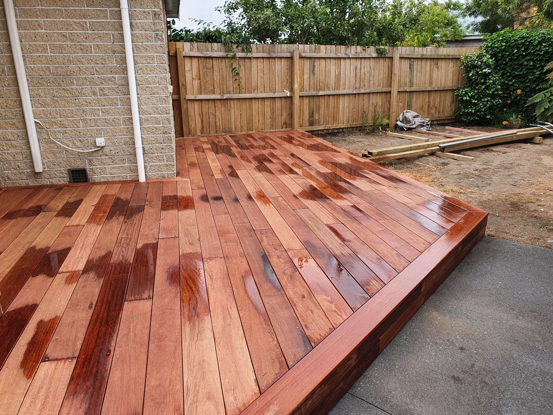 A wooden deck with a wooden fence in the background