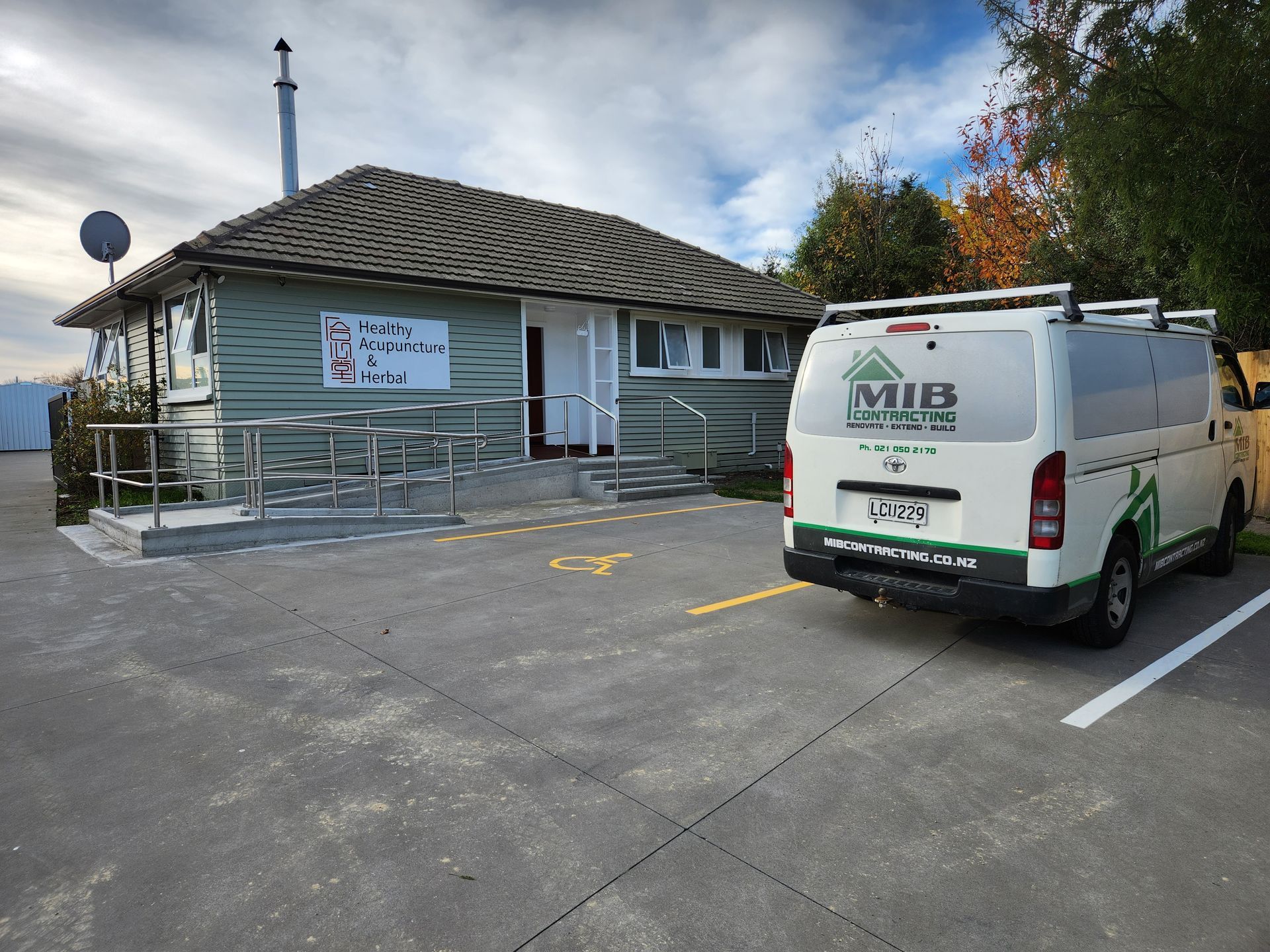 A white van with the word mib on the back is parked in front of a house.