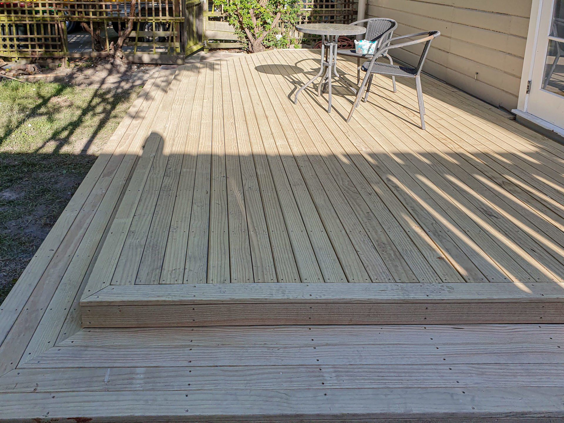 A wooden deck with a table and chairs on it.