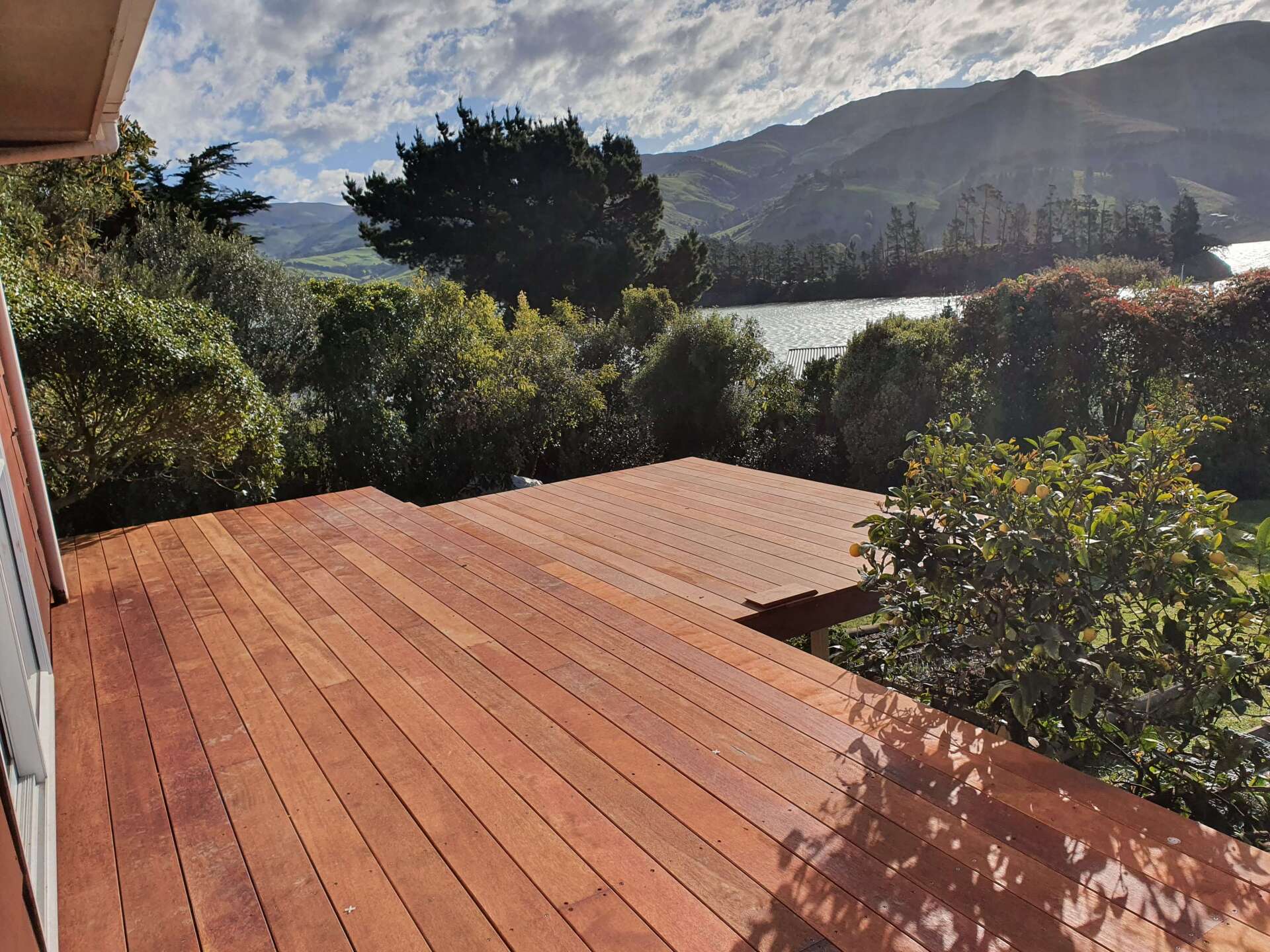 A wooden deck with a view of a lake and mountains