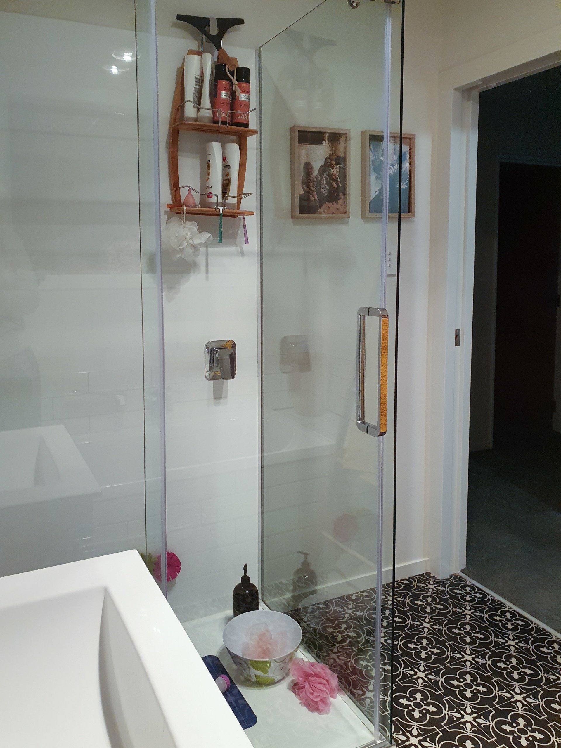 A bathroom with a walk in shower and a sink.