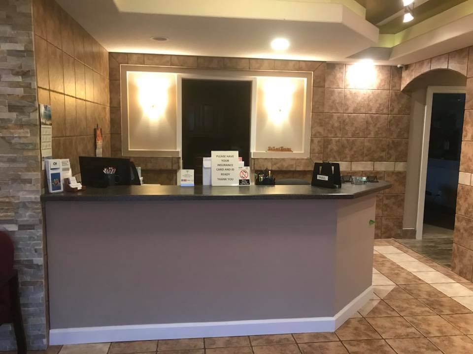 A reception desk in a hotel with a laptop on it