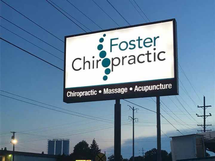 A billboard for foster chiropractic is lit up at night