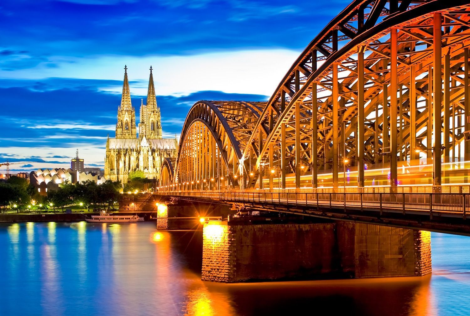 A bridge over a river with a cathedral in the background.