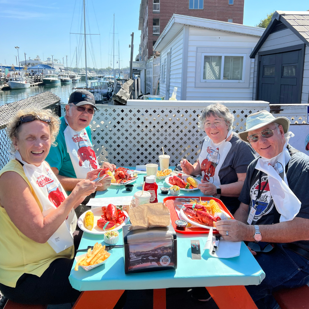 A group of people are sitting at a table eating Lobster