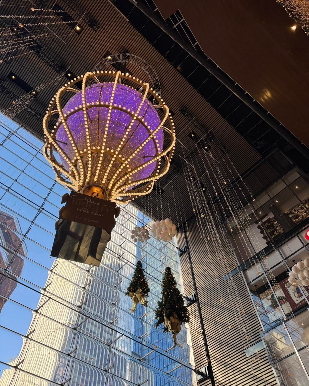 A purple hot air balloon is hanging from the ceiling of a building