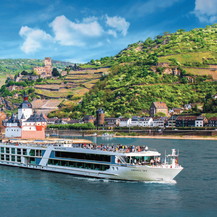 River cruise ship sailing on a blue river near green hills and a medieval castle. Sunny day.