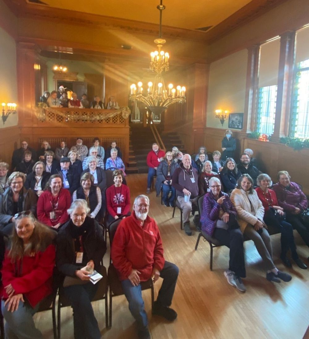 A large group of people are sitting in chairs in a room.