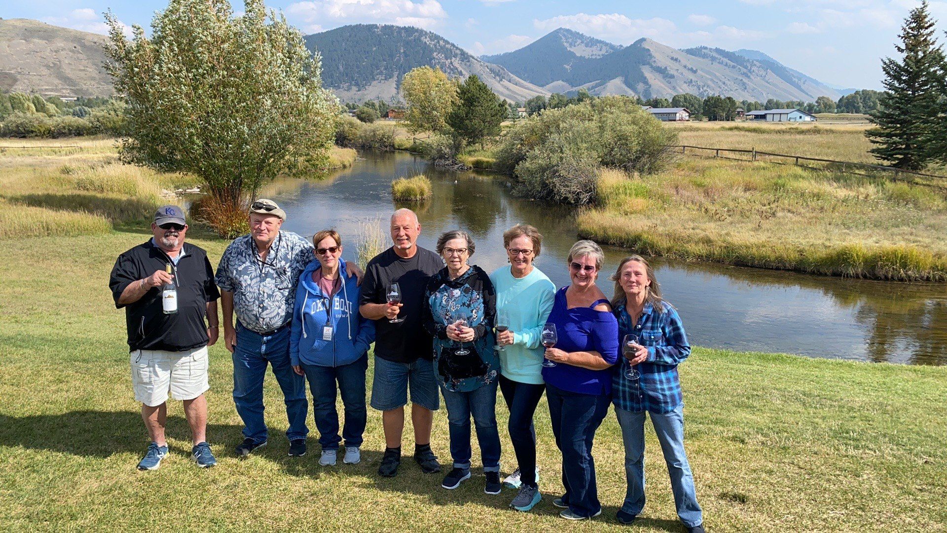 A group of people are posing for a picture in front of a river.
