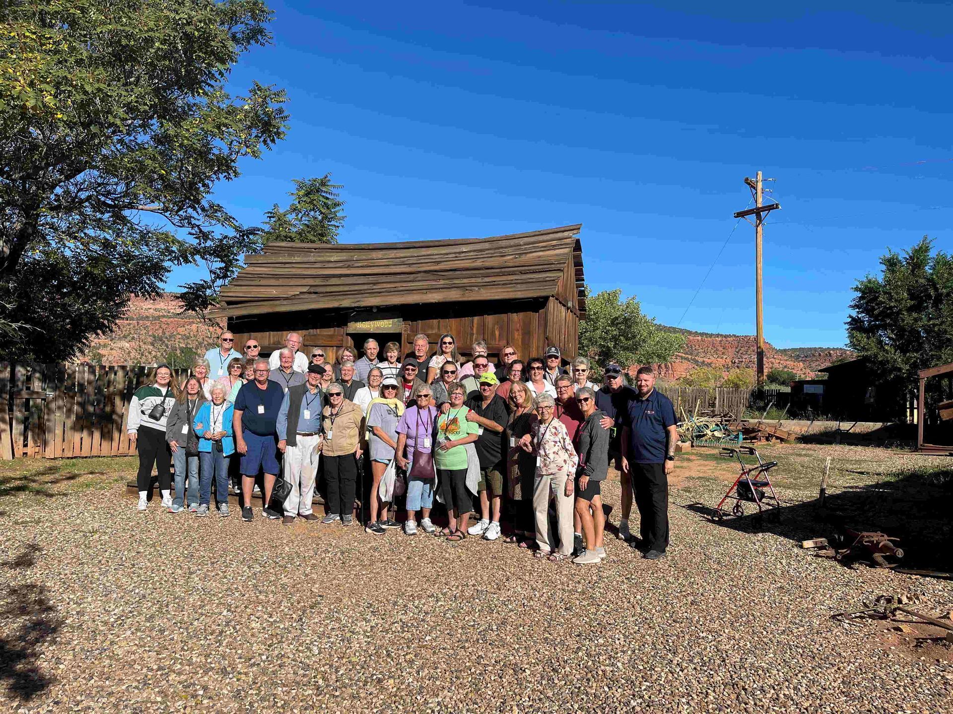 A group of people are posing for a picture in front of a wooden building.