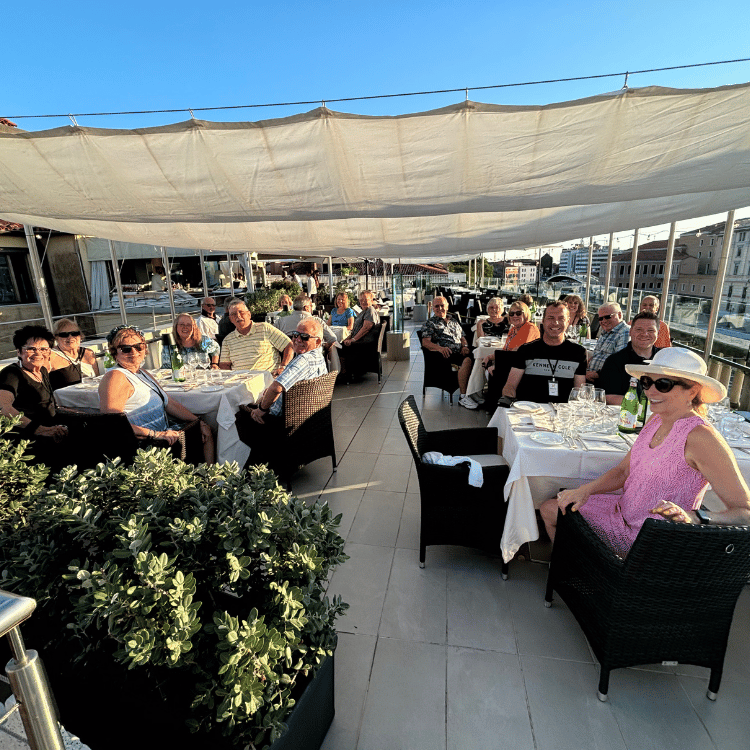 A group of people are sitting at tables under a canopy
