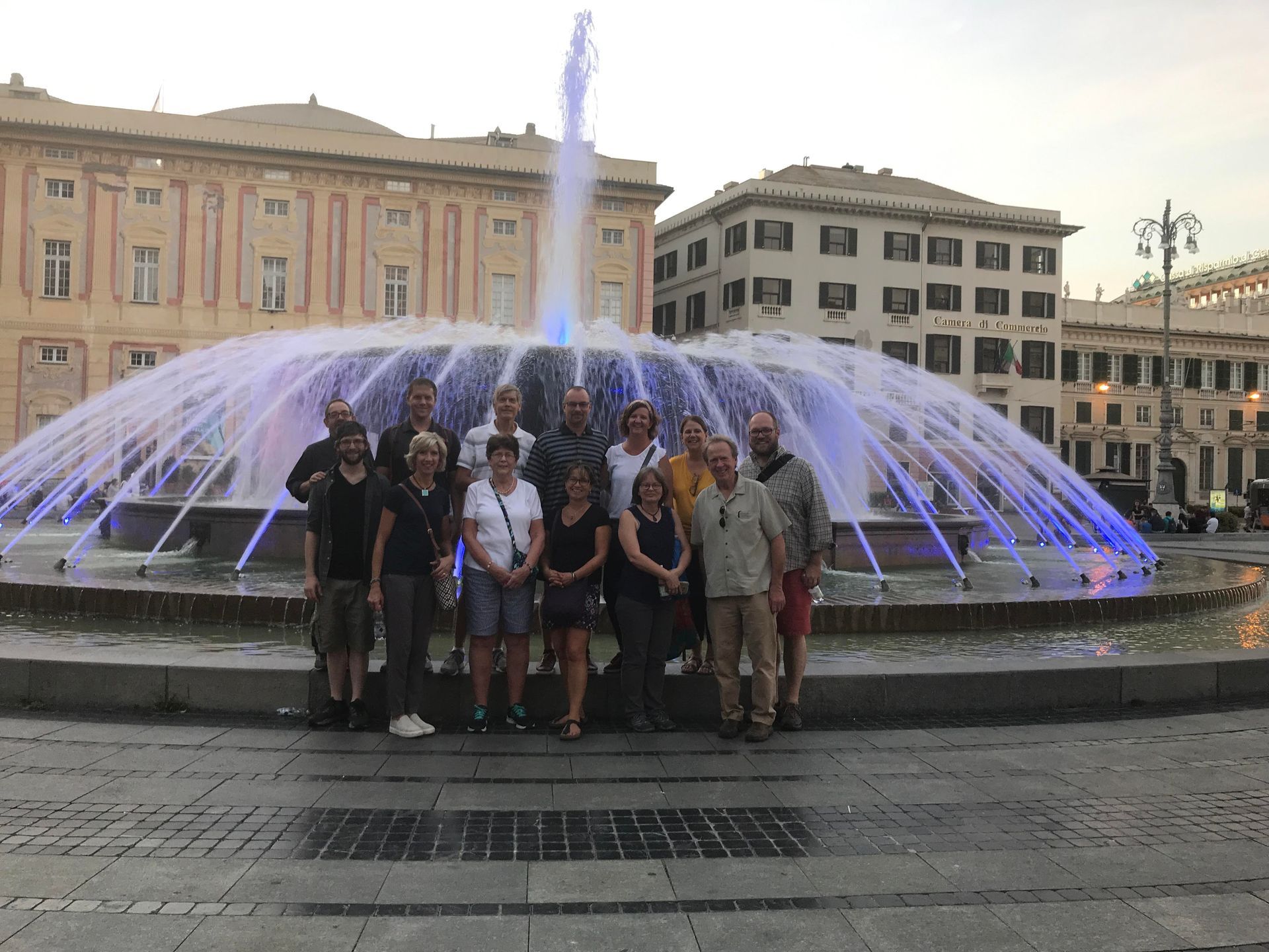 A group of people are posing for a picture in front of a fountain.