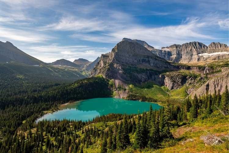There is a lake in the middle of a mountain surrounded by trees.