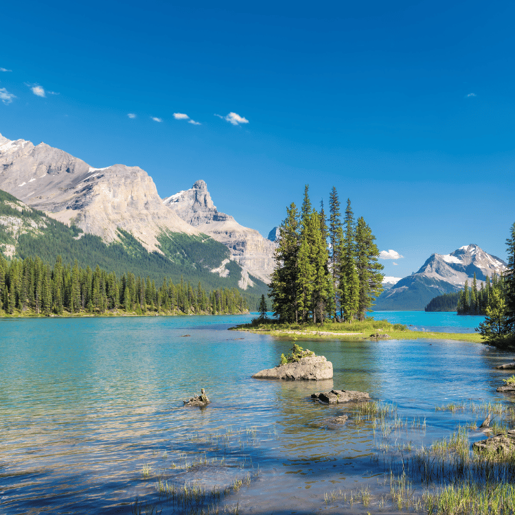 Lake with island, mountains, and blue sky; a scenic outdoor landscape.