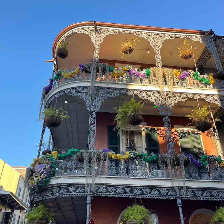 A large building with a balcony decorated for mardi gras.