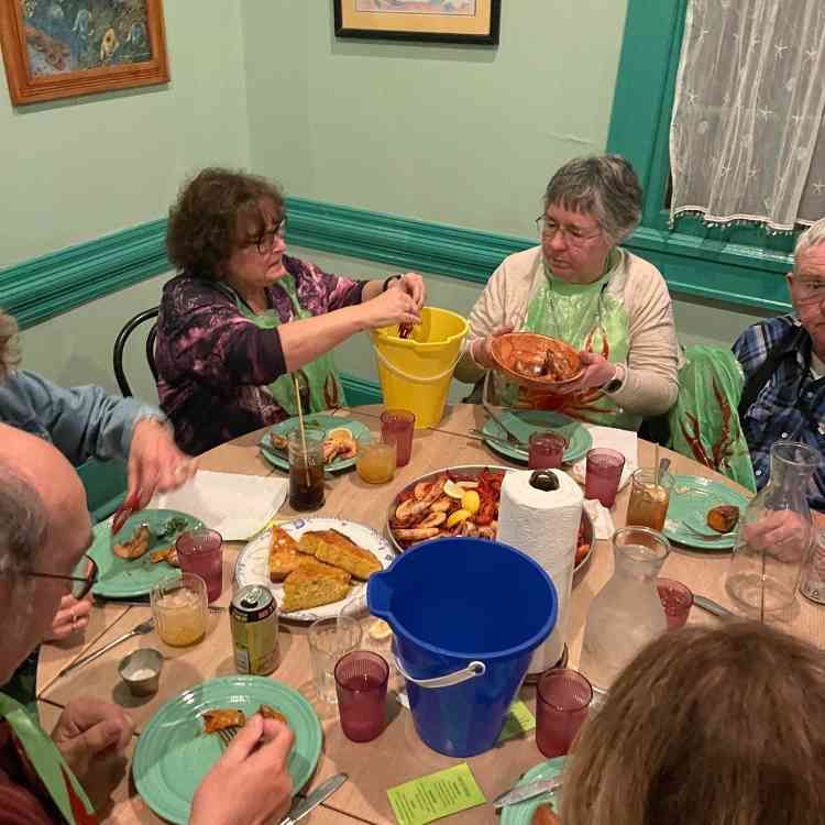 A group of people are sitting around a table eating food.