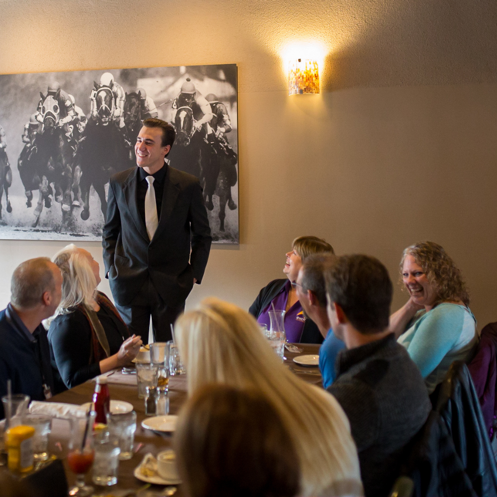 A man in a suit and tie is giving a presentation to a group of people
