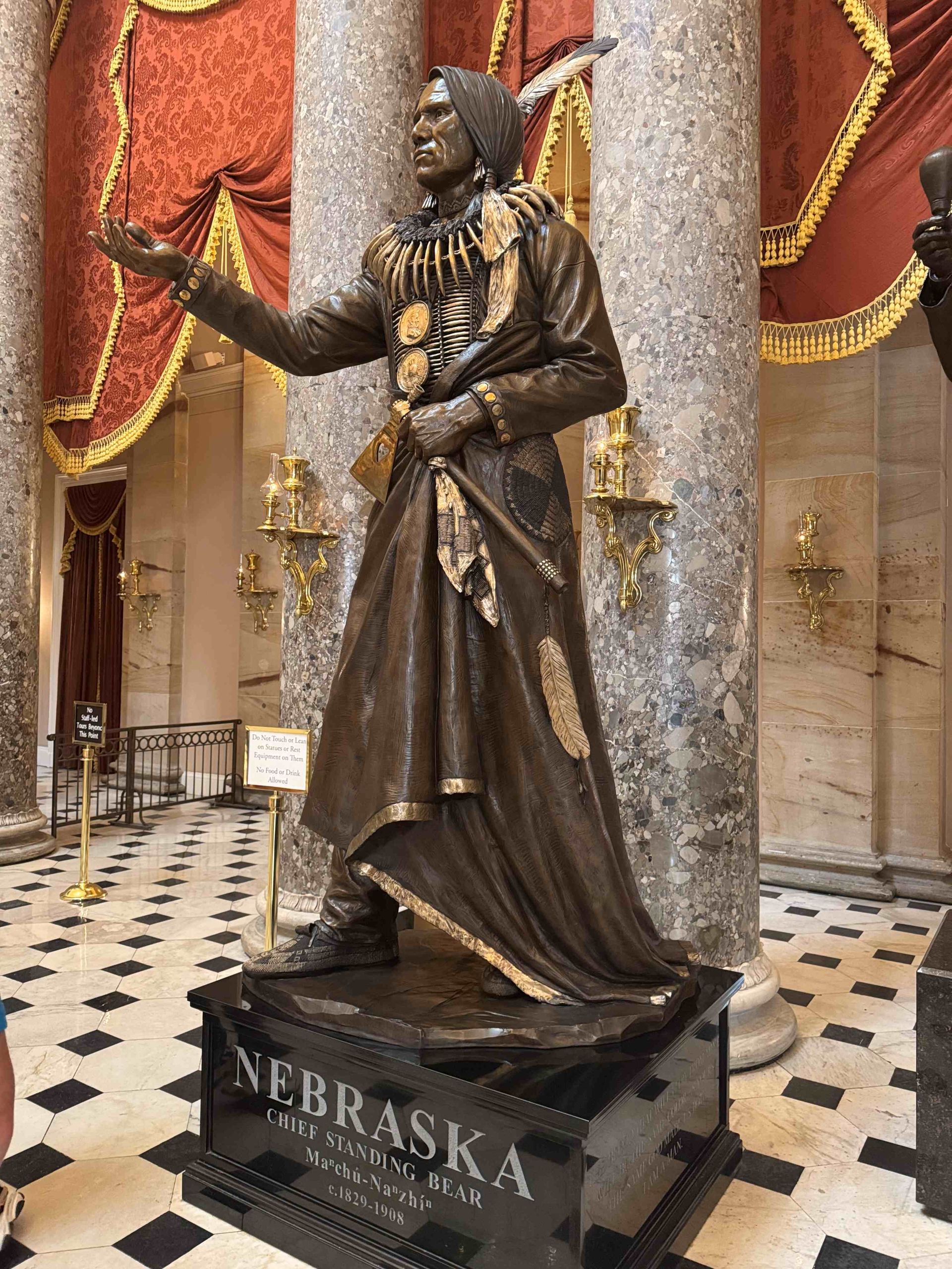 A bronze statue of a native american in a hallway.