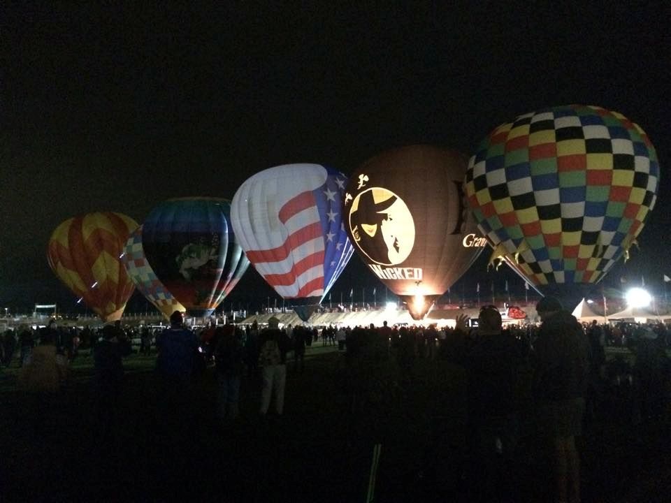 A group of hot air balloons are lit up at night