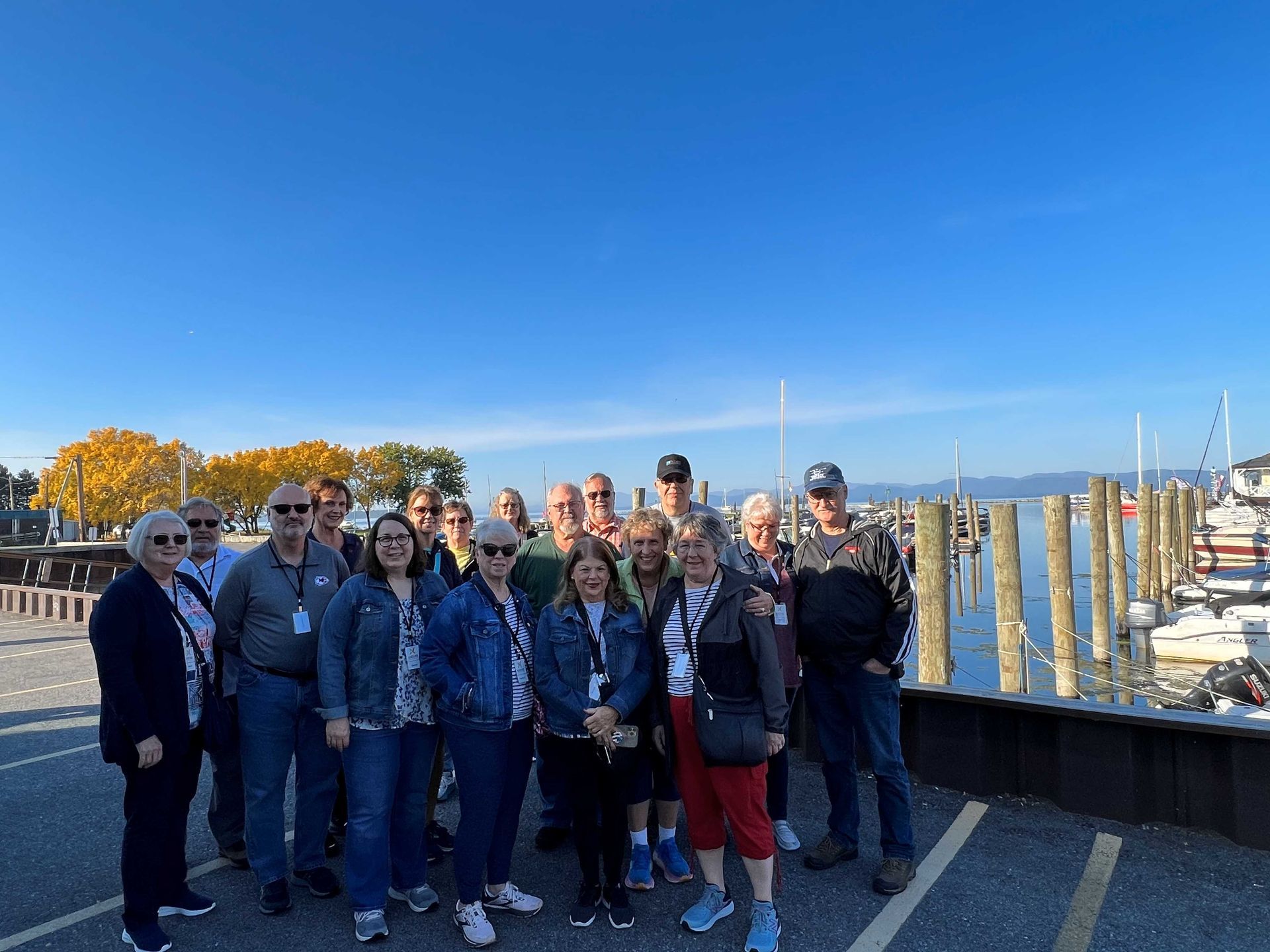 A group of people are posing for a picture in front of a body of water.