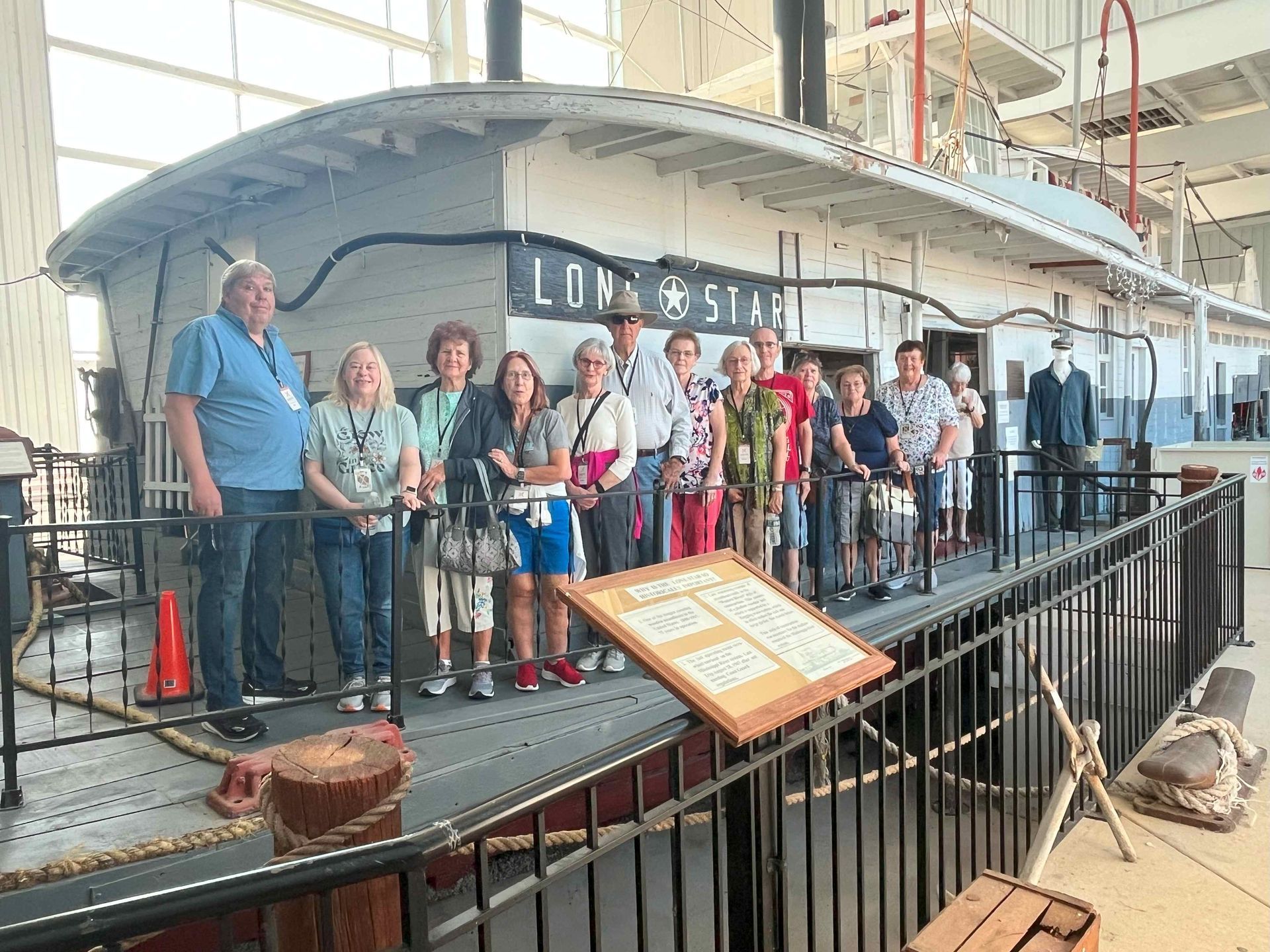 A group of people are standing in front of a boat.