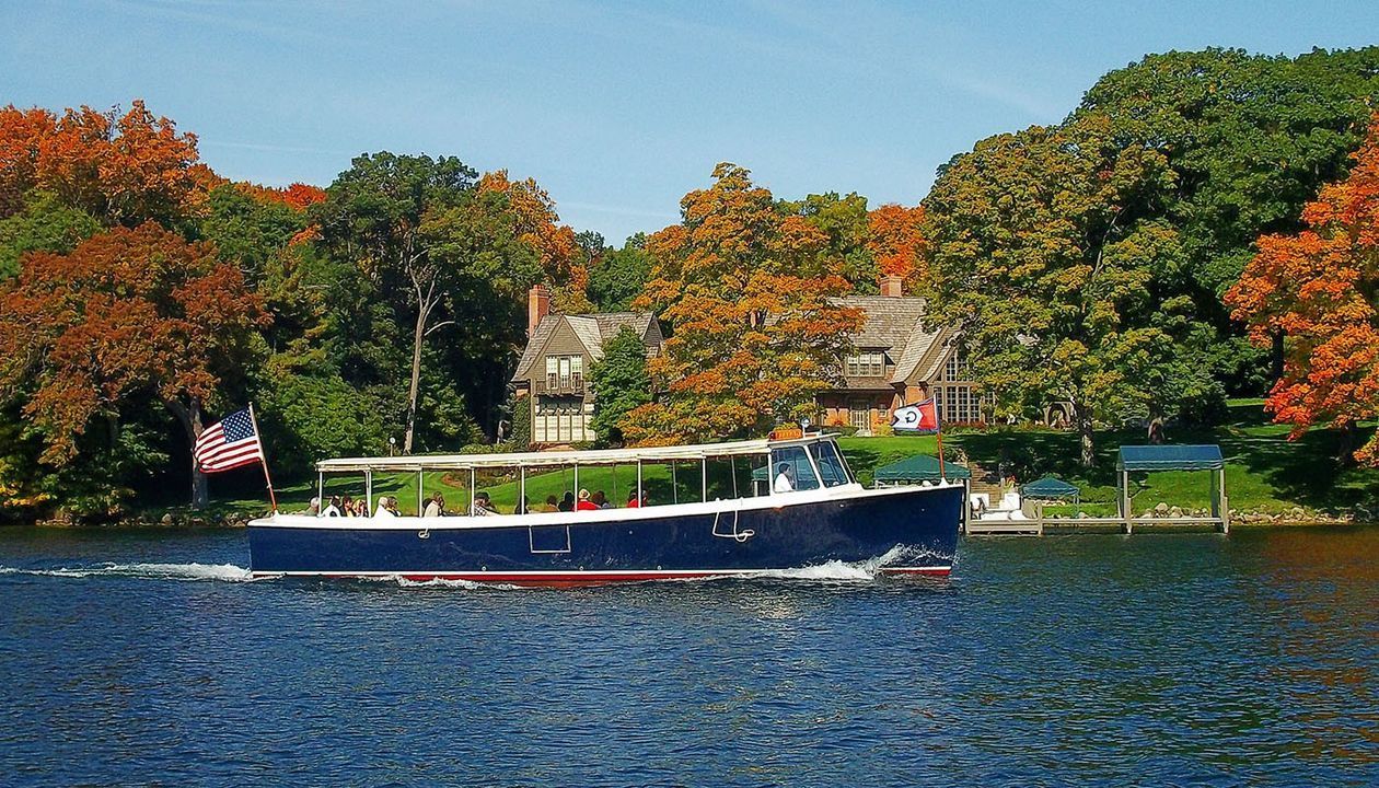 A boat is floating on a lake with a house in the background
