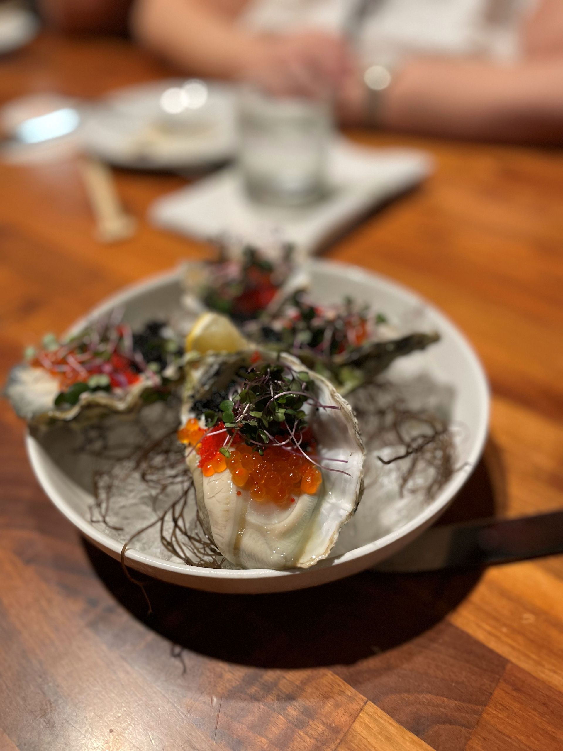 A close up of a plate of food on a wooden table.