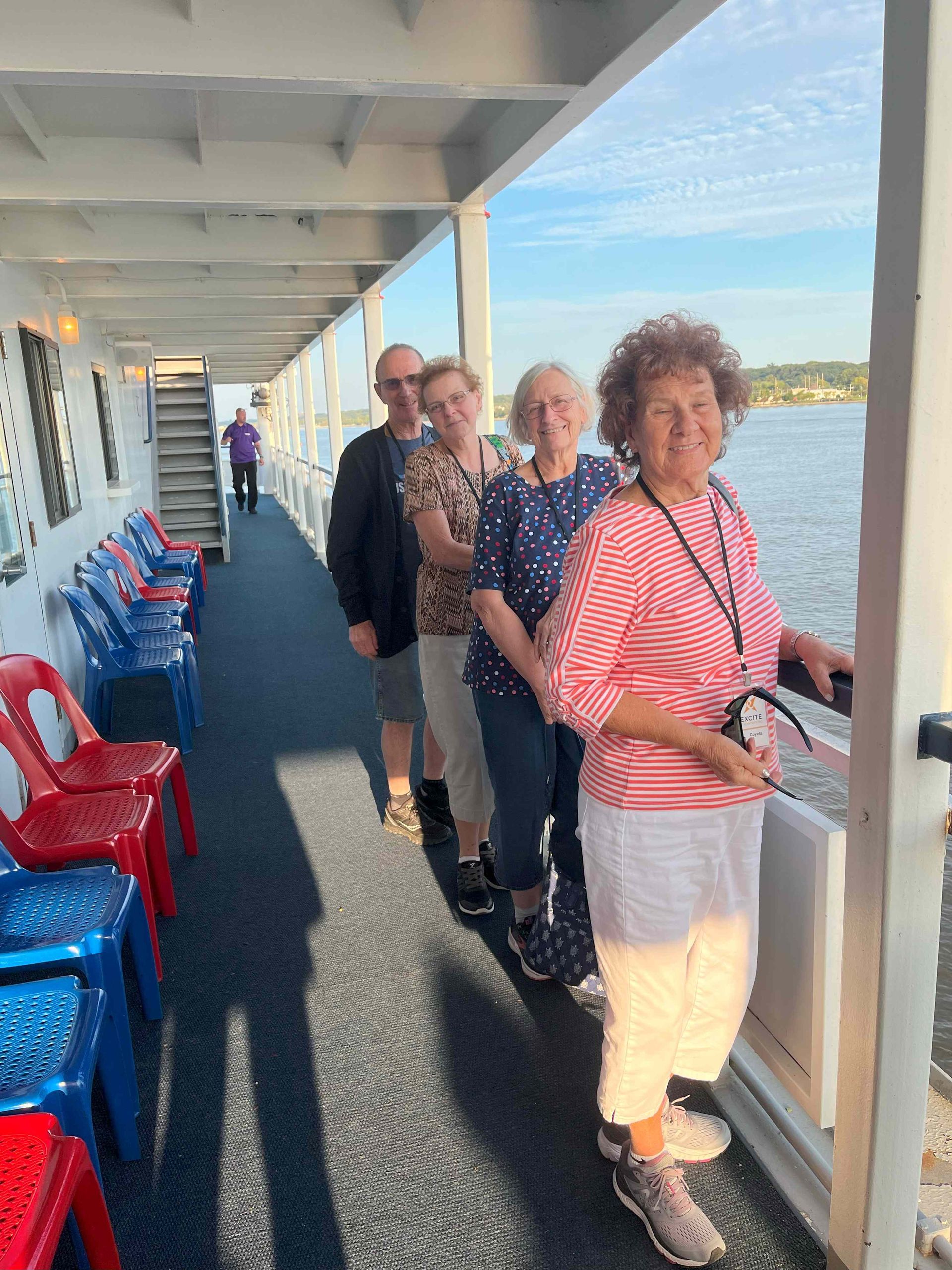 A group of people are standing on the deck of a boat.