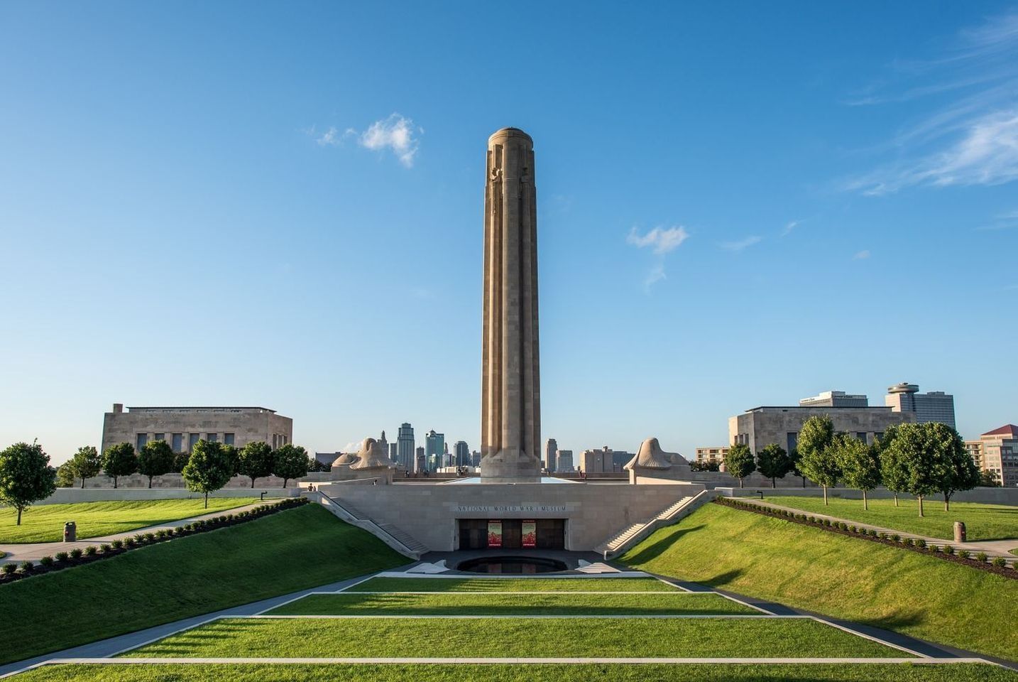 A large stone tower is in the middle of a grassy field.