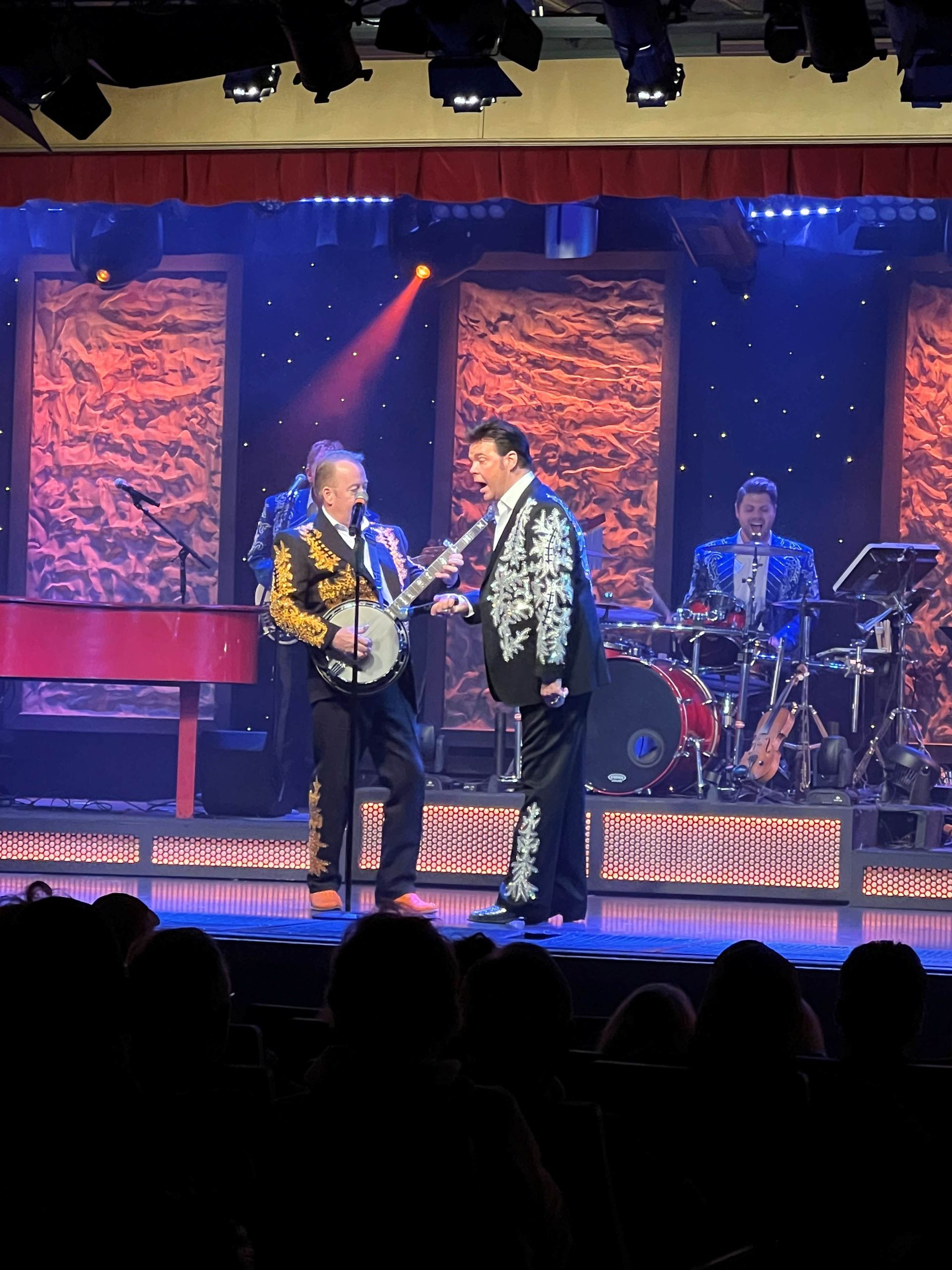 A man playing a banjo and another man playing a guitar on a stage