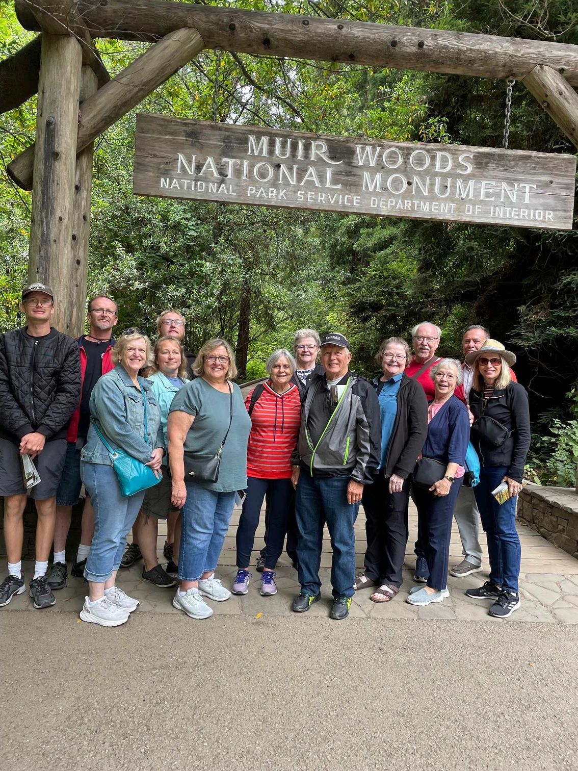 A group of people are posing for a picture in front of a sign.