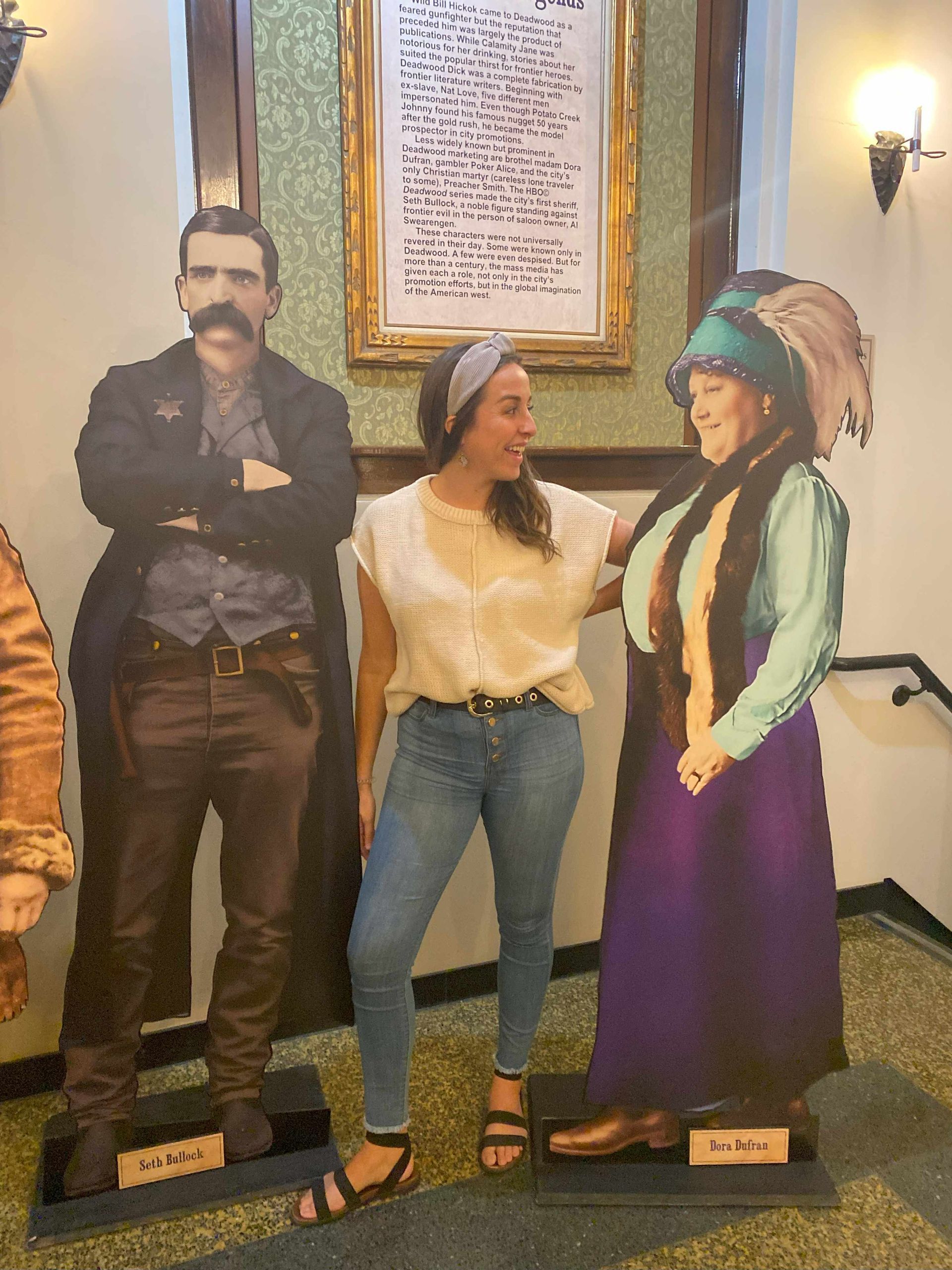 A woman standing next to a cardboard cutout of a man and a woman