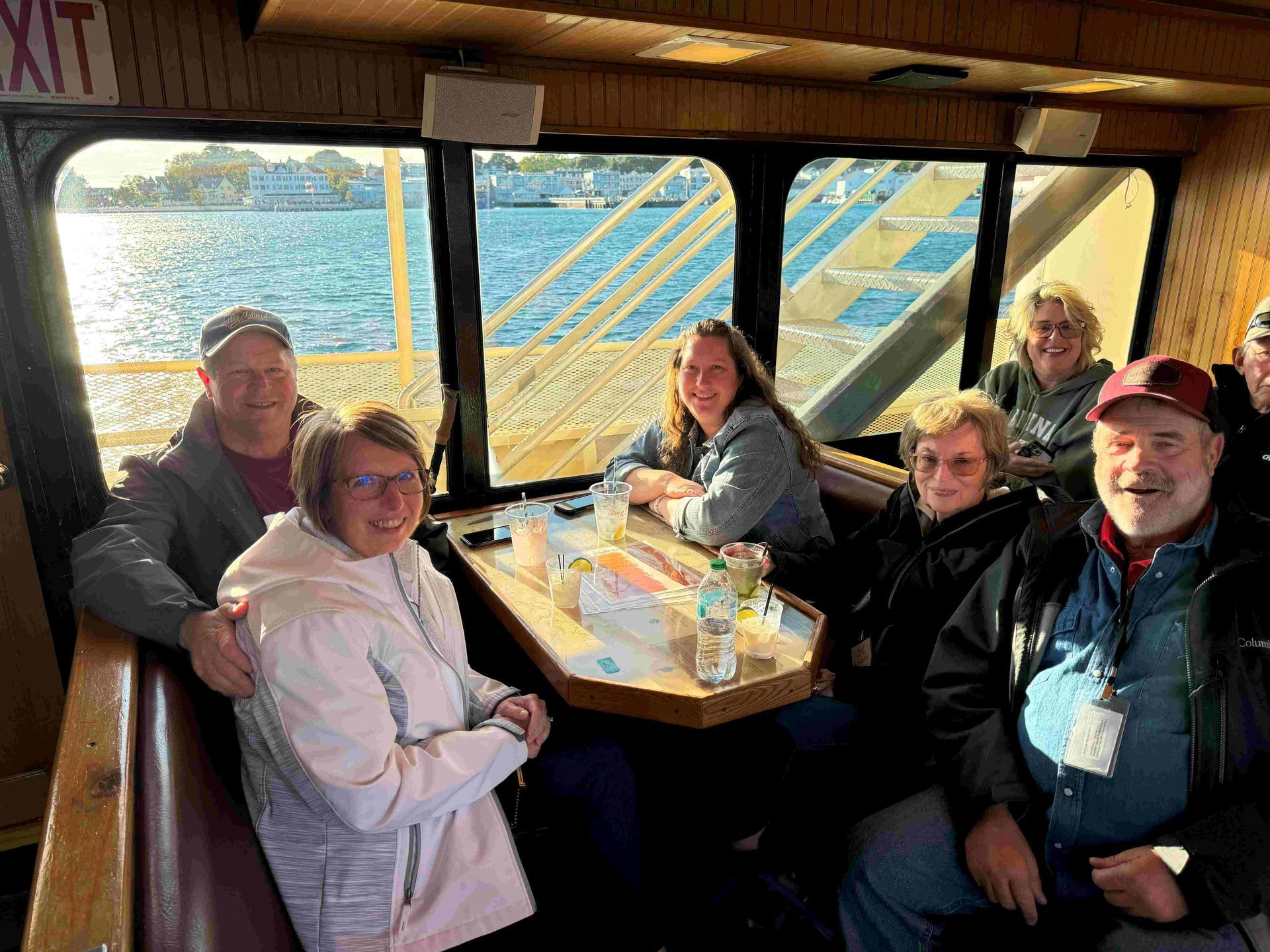 A group of people are sitting at a table on a boat.