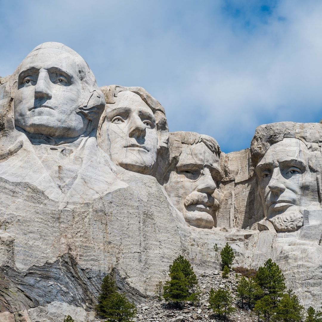 A group of statues of presidents on top of a mountain.