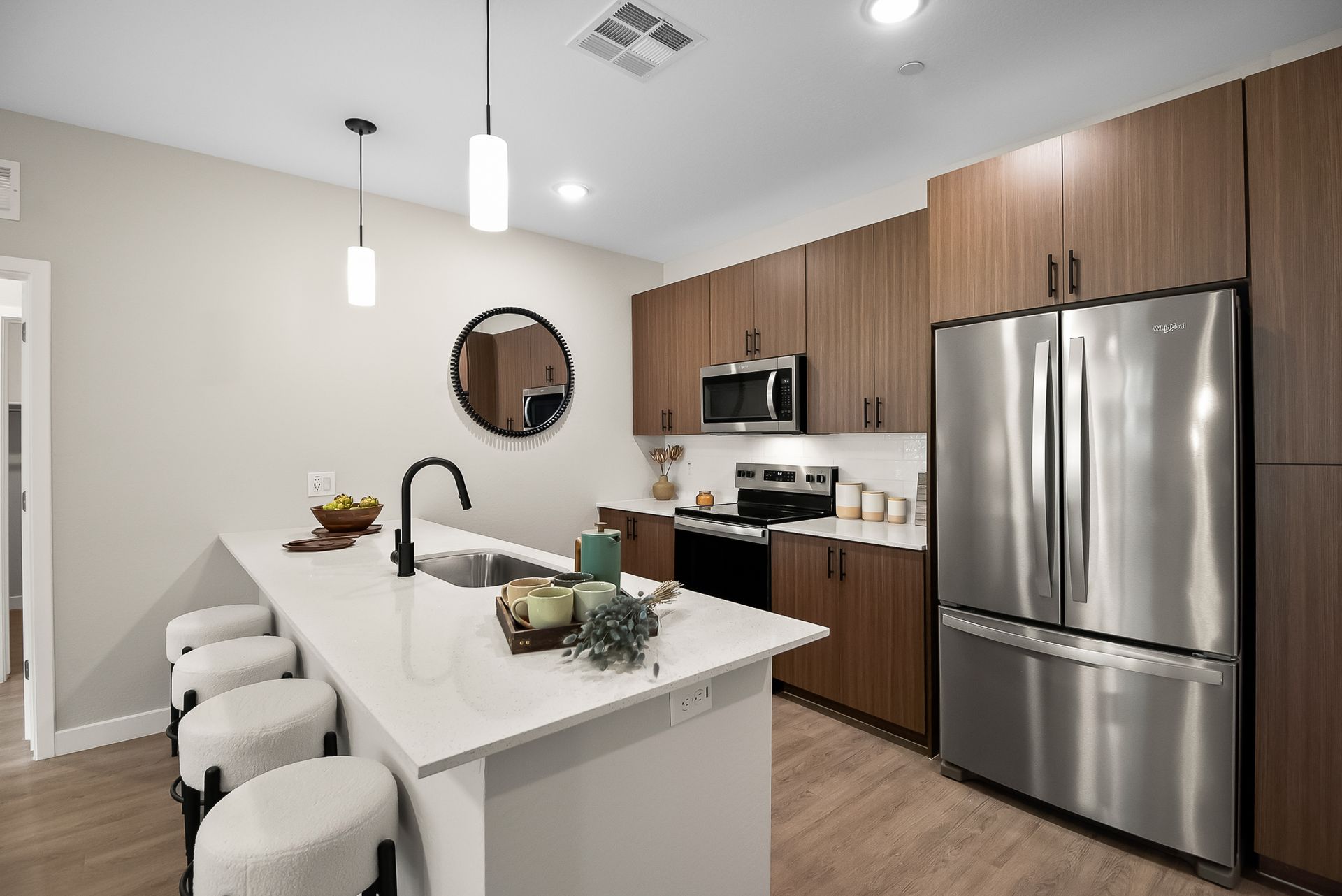 A kitchen with stainless steel appliances and wooden cabinets at Origin, which offers apartments in Goodyear, AZ.