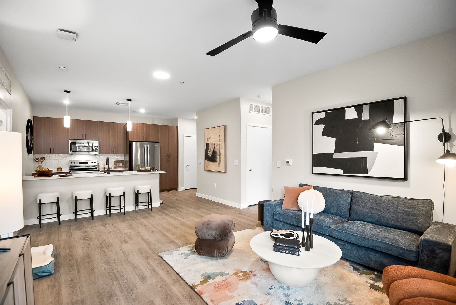 A living room with a couch, table, chairs and a ceiling fan at Origin, which offers apartments for rent in Goodyear, AZ.