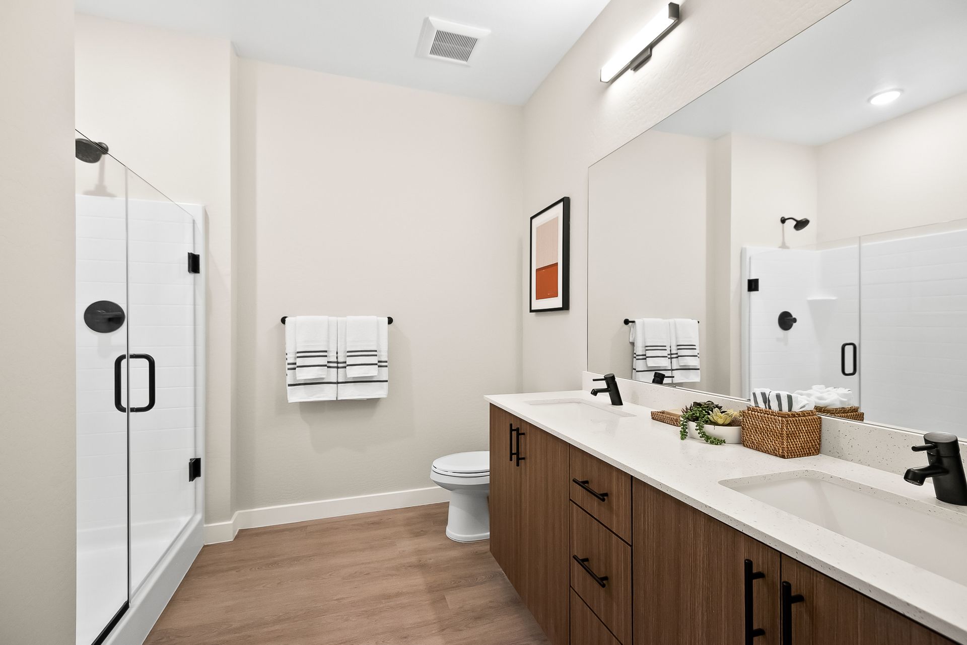 A bathroom with a toilet, sink, and shower at Origin, which offers apartments for rent in Goodyear near Buckeye, AZ.