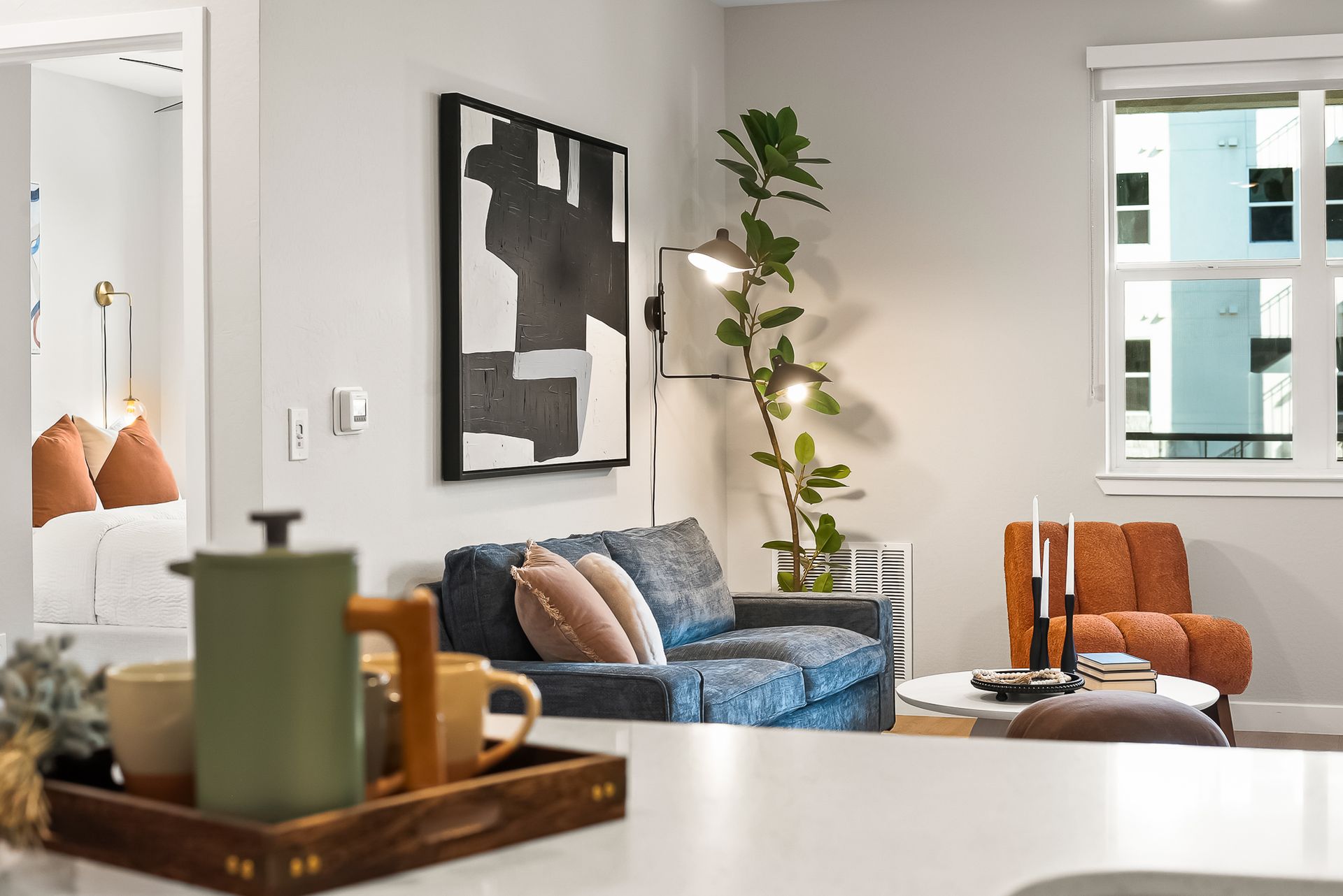 A living room with a couch, chairs, and a tray on the counter at Origin, which offers luxury apartments for rent in Goodyear, AZ.