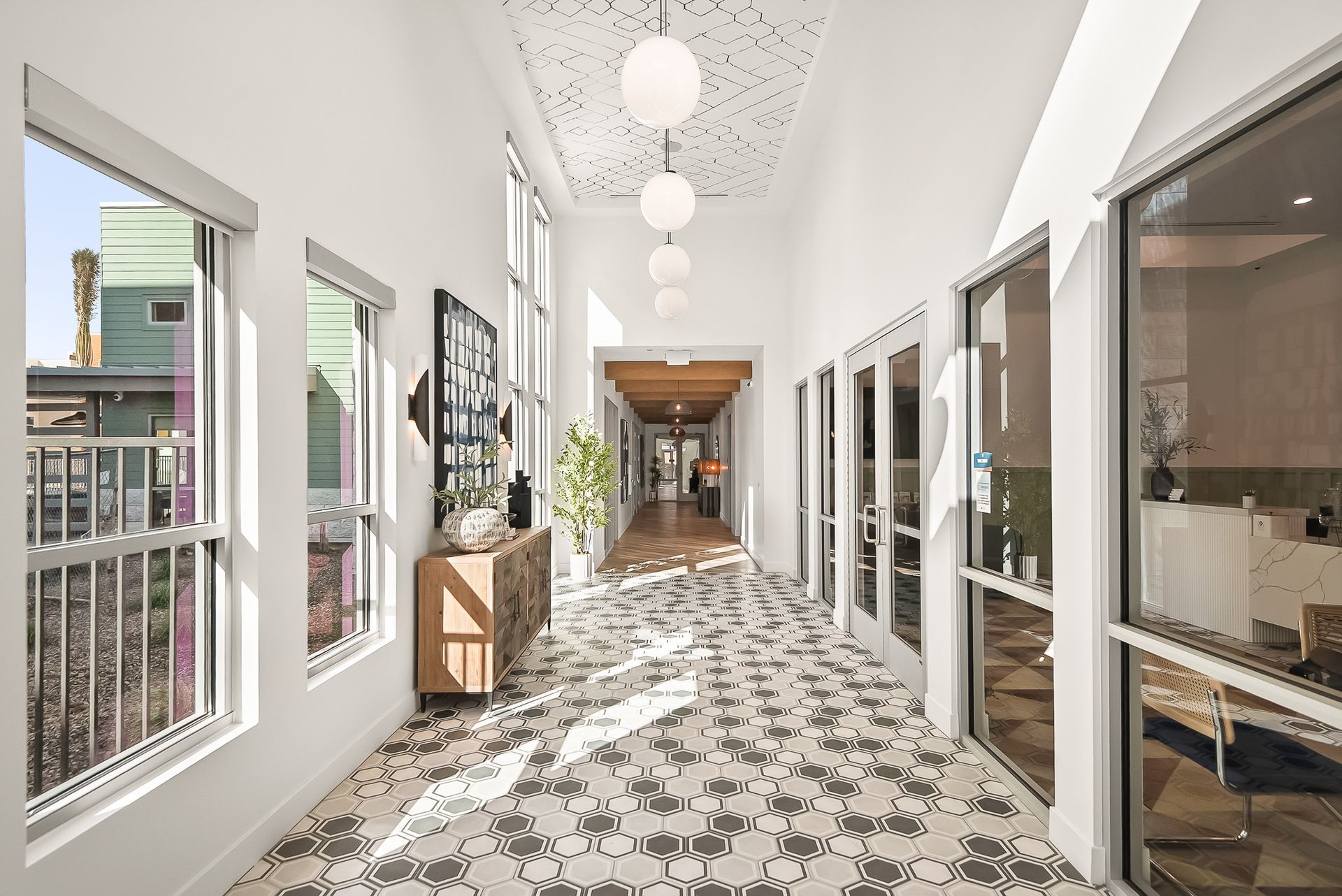 An artist's impression of a long hallway with lots of windows at Origin, which offers apartments for rent in Goodyear, AZ.