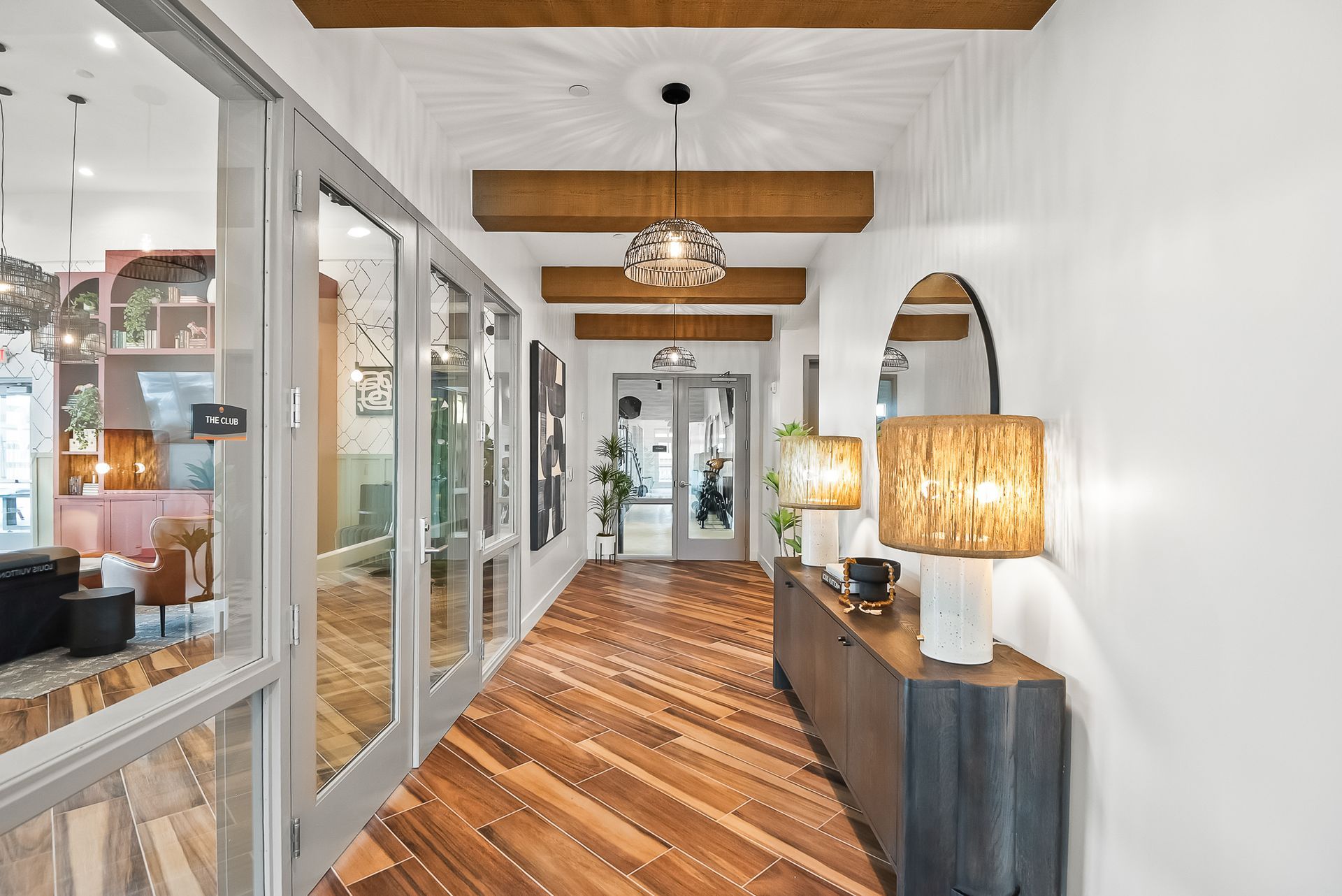 A long hallway with a wooden floor and a mirror at Origin, which offers apartments for rent near Buckeye, AZ.