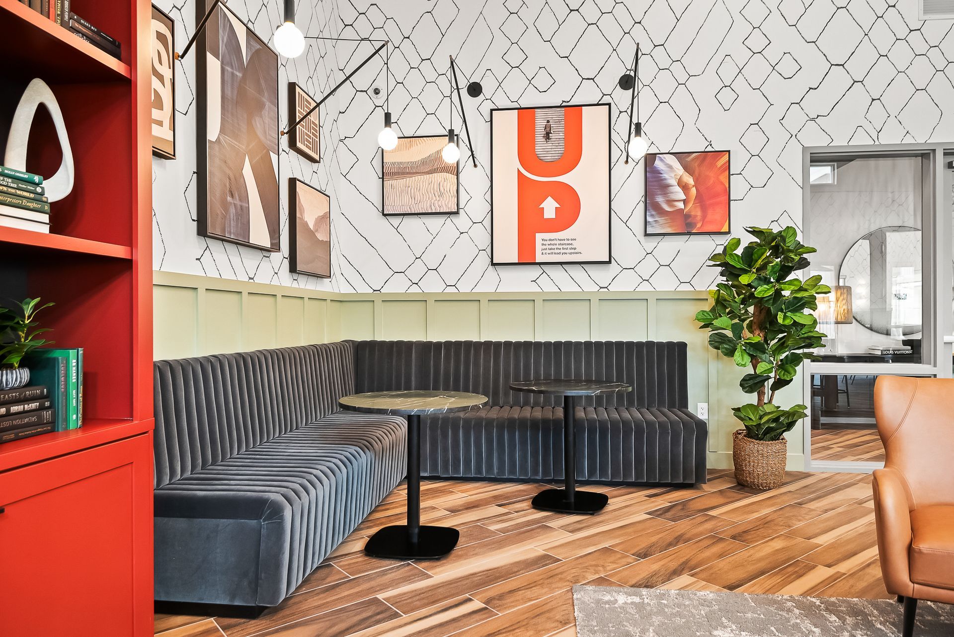 Resident lounge with a couch, chairs, tables and a bookshelf at Origin, which offers apartments for rent in Goodyear, AZ.