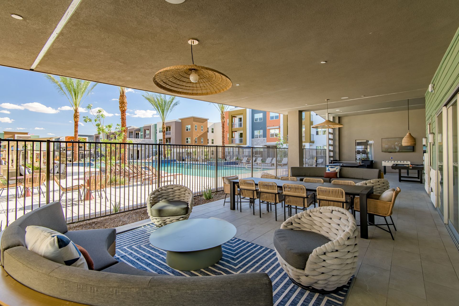 A large patio with a couch, chairs, table and pool table at Origin, which offers luxury apartments for rent in Goodyear, AZ.