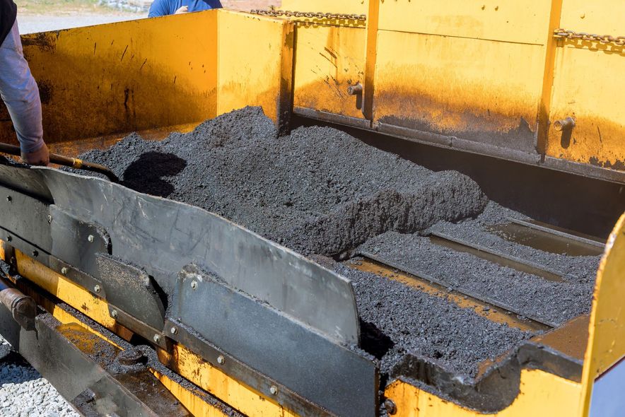 A person is pouring concrete into a yellow container.