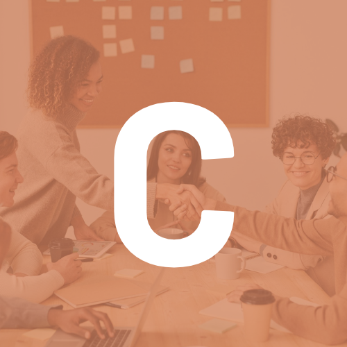A group of people are sitting around a table with the letter c in the foreground