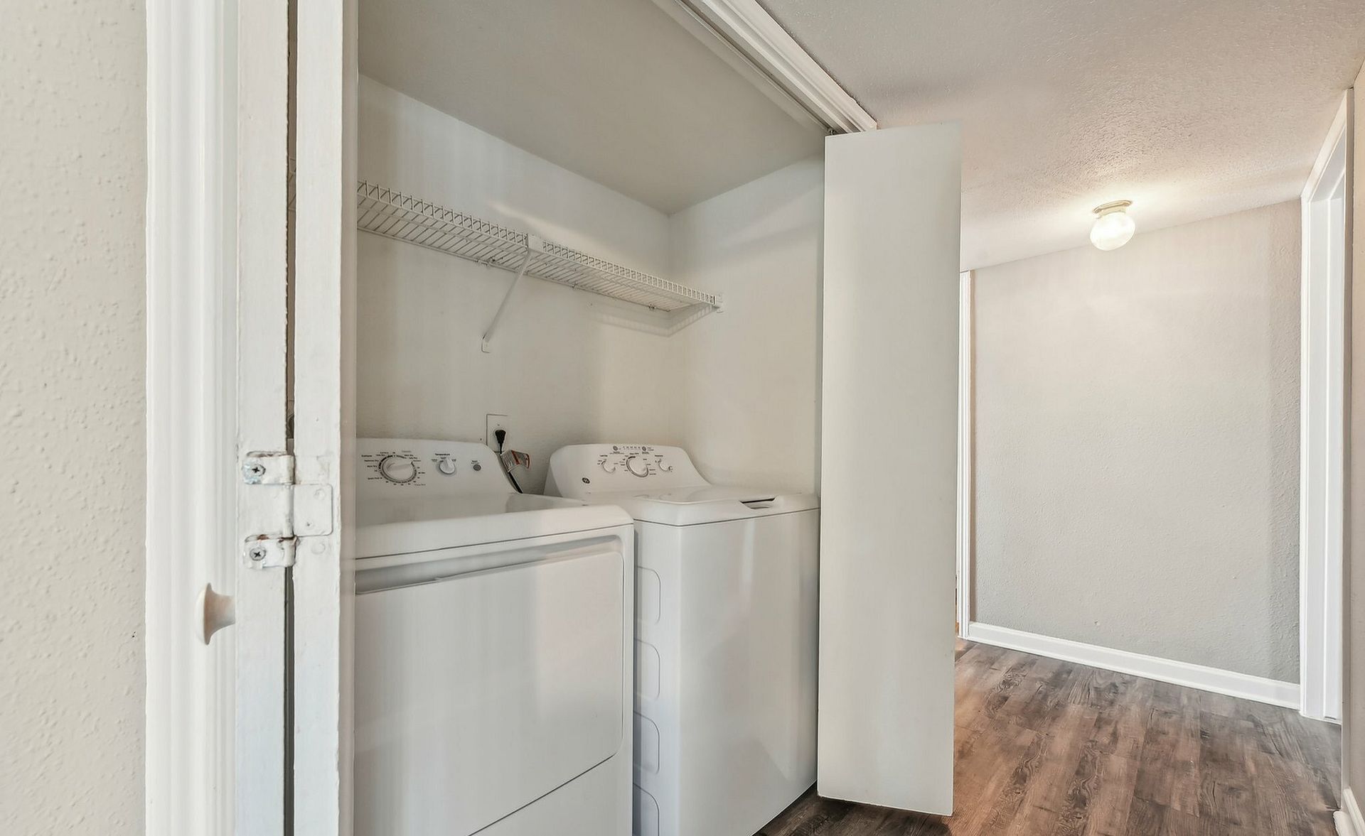 Laundry closet with a pair of white washer and dryer side by side.